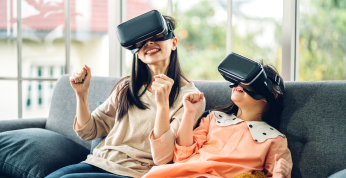 Madre e hija sentadas en un sofá con gafas VR