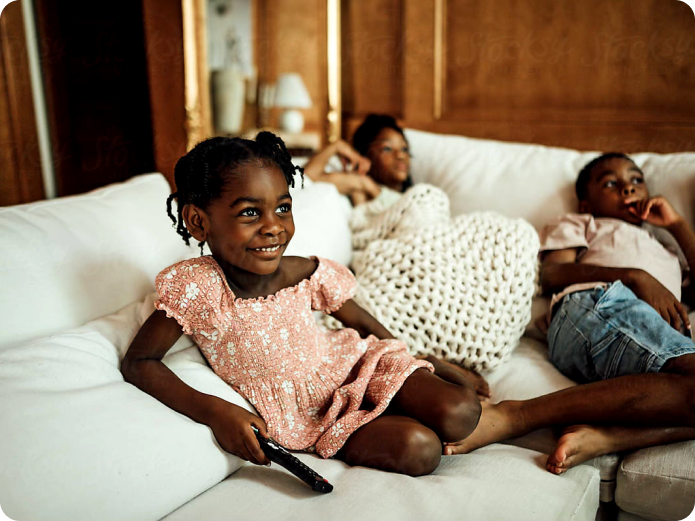 Woman on couch with children watching tv