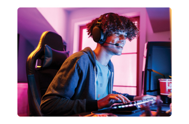 Boy sitting in front of compouter with headset gaming