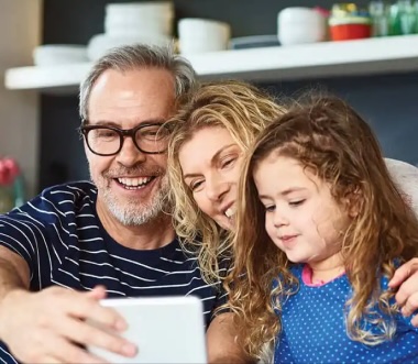 mom dad child looking at device