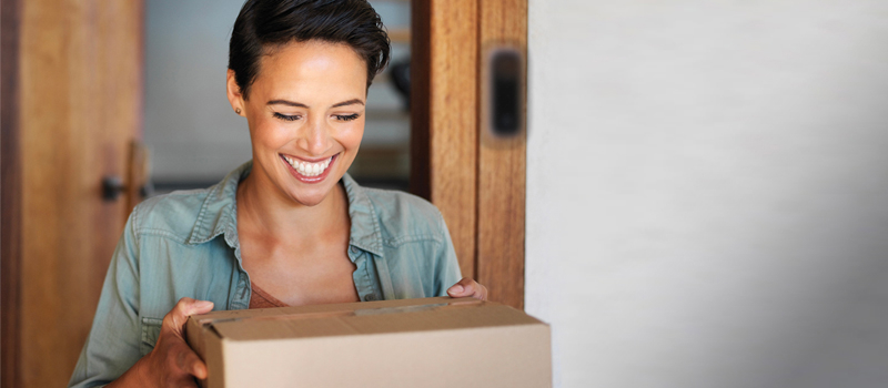 Mujer sonriente con una caja de Cox Homelife