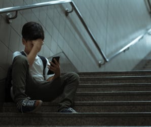 Boy sitting on stairs on phone
