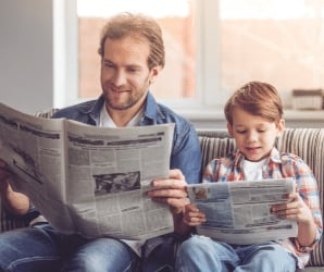 Father and son reading newspaper