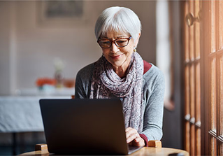 A woman wearing scarf working on a laptop